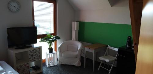Zimmer mit einer grünen Wand, einem Stuhl und einem Schreibtisch in der Unterkunft Maisonette-Ferienzimmer Am Backhausgarten in Flonheim