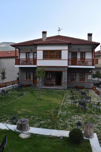 a large house with a yard with tables and chairs at NUCA GUESTHOUSE in Metsovo