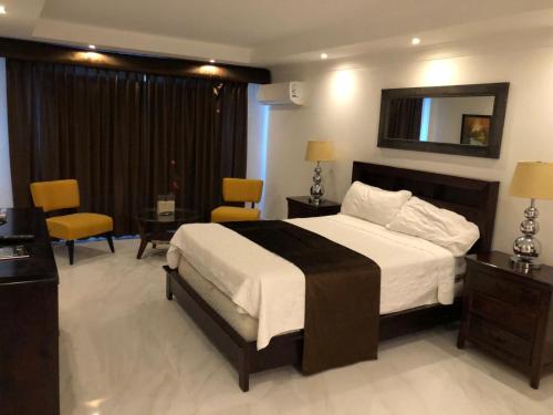 a hotel room with a bed and a table and chairs at Golden House Hotel & Convention Center in Santo Domingo