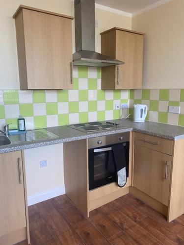 a kitchen with a sink and a stove top oven at Nantwich House in Crewe