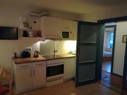 eine kleine Küche mit weißen Schränken und einem Waschbecken in der Unterkunft Gartenwohnung in Nieblum