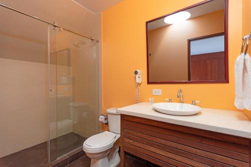 a bathroom with a toilet, sink, and shower at GIO Suites Parque 93 Bogotá in Bogotá
