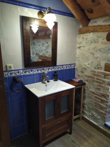 a bathroom with a sink and a mirror at Casa Rural Las Cotarras in Sanchonuño