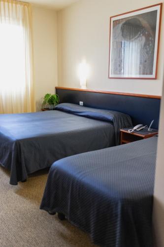 a hotel room with two beds and a window at Hotel Crystal in Preganziol