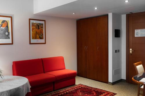 a living room with a red couch and a table at Hotel Crystal in Preganziol