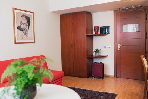 a living room with a red couch and a table at Hotel Crystal in Preganziol