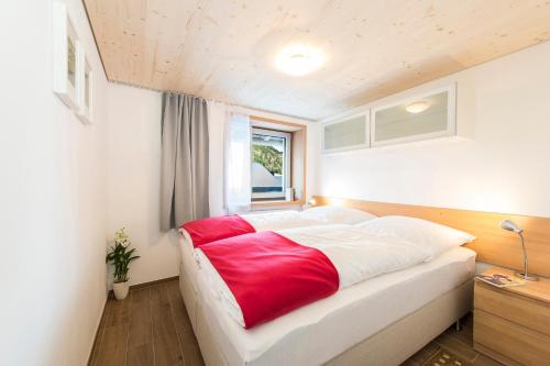 a bedroom with a large bed with a red blanket at Fewo Nachbaur Typ C1 in Oberjoch