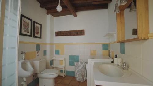 a bathroom with a toilet and a sink and a urinal at Casa La Monja in Garachico