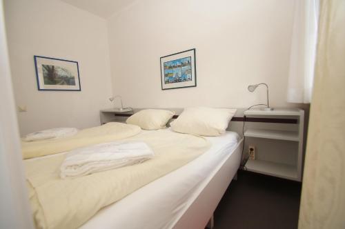 2 camas en una habitación con sábanas blancas en An der Allee 20 A, en Dahme