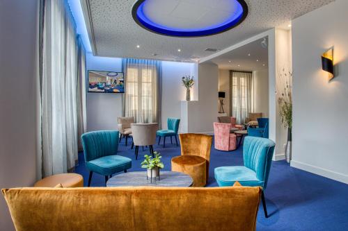 a waiting room with blue chairs and a blue ceiling at Hôtel Montaigne in Sarlat-la-Canéda