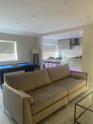 a living room with a couch and a pool table at Luxe bungalow Bradford in Wibsey