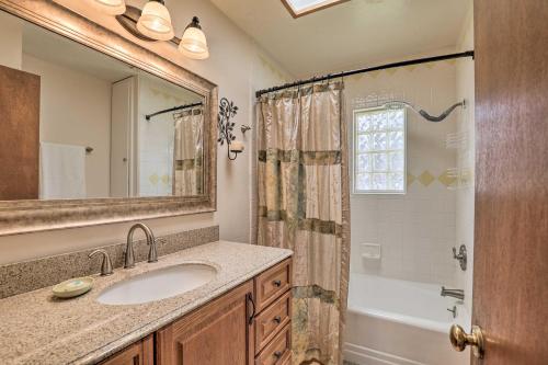 a bathroom with a sink and a tub and a mirror at Bisbee Home Less Than half Mi to Park and Tennis Courts! in Bisbee
