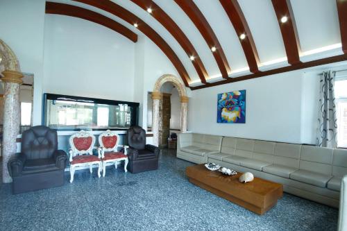uma sala de estar com um sofá, cadeiras e uma mesa em Villa Jhoana Resort em Angono