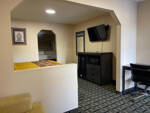 a hotel room with a bar with a tv and a desk at New Hampshire Inn West Memphis in West Memphis