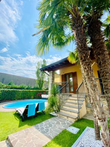 a house with a palm tree and a swimming pool at Franciacorta Suite in Corte Franca