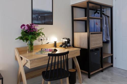 a wooden desk with a vase of flowers on it at Trendy Hotel by Athens Prime Hotels in Athens