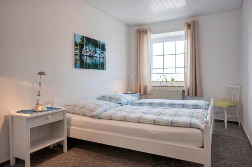 フェーマルンにあるKnusthof Lafrenz - Goldblickの白いベッドルーム(ベッド1台、窓付)