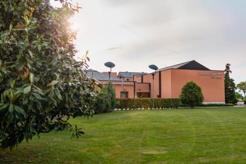a building with a grass field in front of it at Hotel Crystal in Preganziol