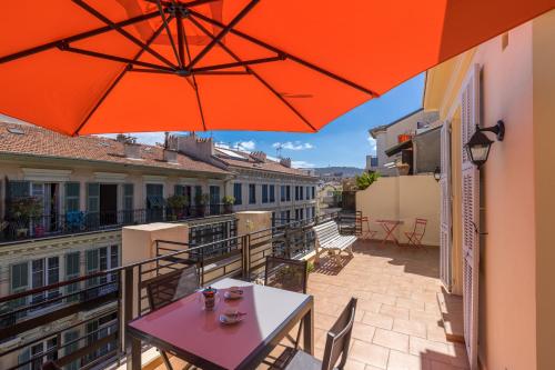 un balcon avec une table et un parasol dans l'établissement Open Sky Terrace Downtown Studio, à Nice