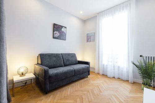 un salon avec un canapé et une fenêtre dans l'établissement Open Sky Terrace Downtown Studio, à Nice