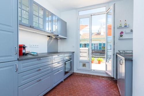 - une cuisine avec des placards bleus et du carrelage rouge dans l'établissement Open Sky Terrace Downtown Studio, à Nice