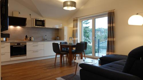 sala de estar con cocina y mesa con sillas en "GESTRANDET" in der Villa Katharina- en Dierhagen