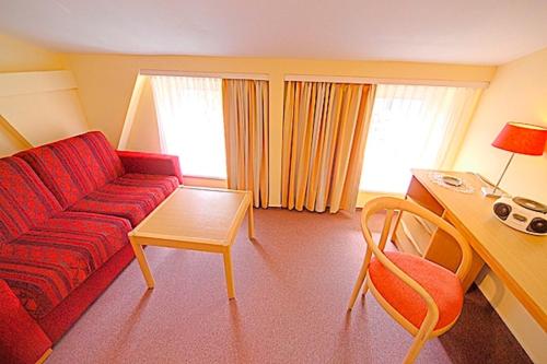 a living room with a red couch and a table at St Michael, FW 1PP am Haus in Zingst