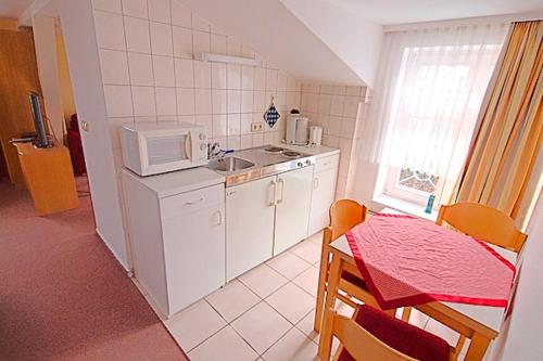 a small kitchen with a sink and a microwave at St Michael, FW 1PP am Haus in Zingst