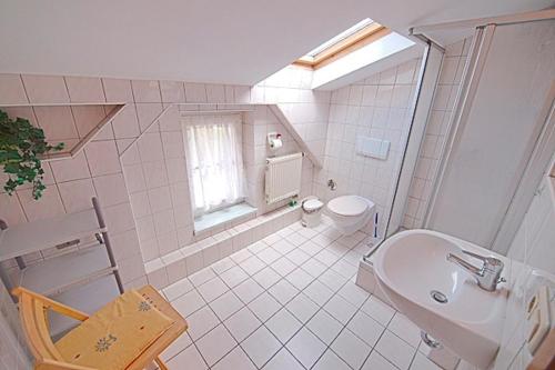 a white bathroom with a sink and a toilet at St Michael, FW 1PP am Haus in Zingst