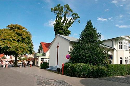a church with a cross on the side of a street at St Michael, FW 1PP am Haus in Zingst