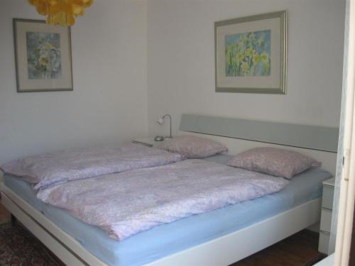 Una cama con dos almohadas rosas encima. en Ferienwohnung Plaggemars Verm nur Sonntag auf Samstag en Seehausen am Staffelsee