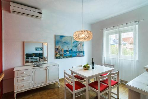 a dining room with a white table and chairs at Apartment Dunja in Supetar