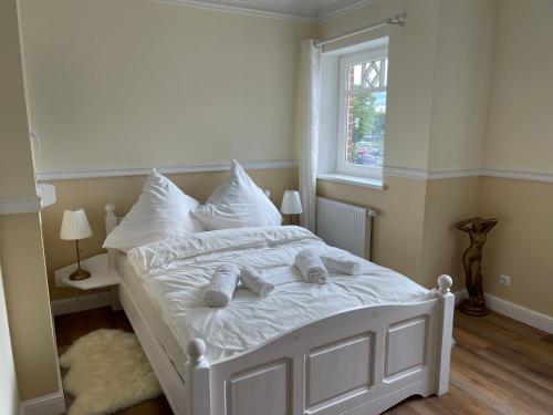 a bedroom with a white bed with towels on it at Zentrales Wohnen auf Zeit nähe Hauptbahnhof und Innenstadt in Lübeck