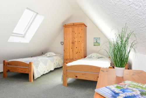 um quarto no sótão com 2 camas e um armário em Muschelsucher em Wrixum