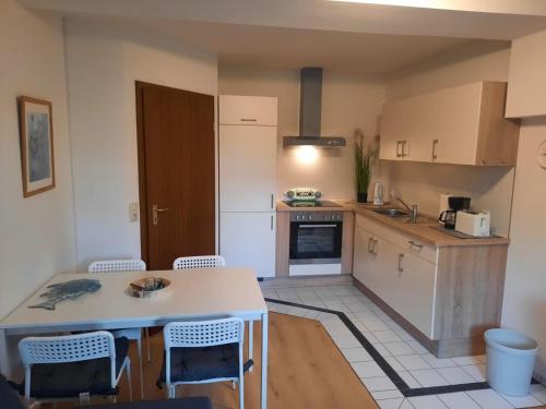 a kitchen with a table and chairs in a room at Nielsen Apartment 1 in Hüsby