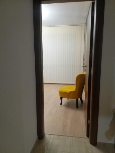 a room with a yellow chair and a door at Sandanski Apartments Top Center in Sandanski