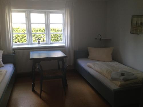 a small bedroom with a bed and a table at Blaue Stube in Nieblum
