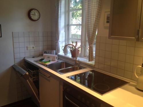 a kitchen with a sink and a clock on the wall at Blaue Stube in Nieblum