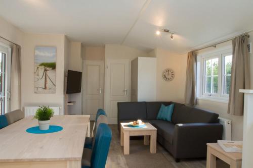 een woonkamer met een bank en een tafel bij Chalet bis 6 Personen ohne Hund - a16982 in Flüthörn