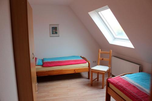 ハイリゲンハーフェンにあるFerienwohnung "Strand Hus 2"のベッドと窓が備わる屋根裏部屋