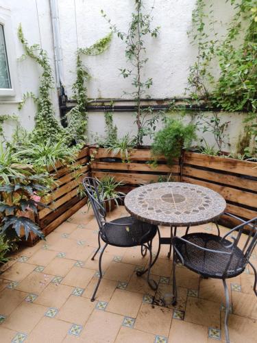 a patio with a table and chairs in a garden at River Ebro Apartments in Móra d'Ebre