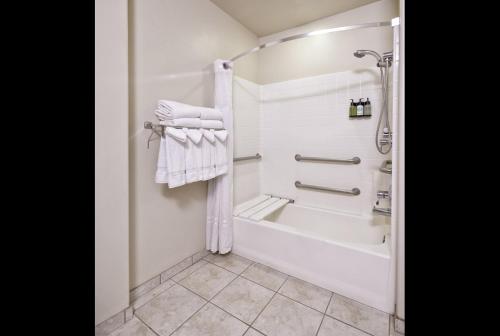 uma casa de banho com um chuveiro e uma banheira com toalhas em Yellowstone Park Hotel em West Yellowstone