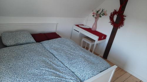 Un dormitorio con una cama y una mesa con un jarrón. en Ferienwohnung im Zanderhaus, en Sabel