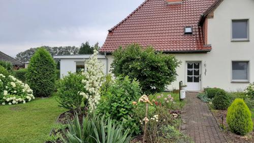 a garden in front of a white house at Ferienwohnung im Zanderhaus in Sabel