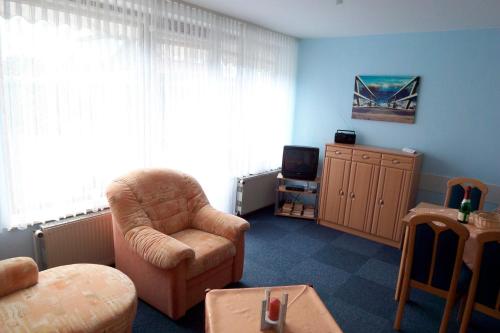 ein Wohnzimmer mit einem Stuhl und einem TV in der Unterkunft Haus Delfin Fewo 4 in Dahme