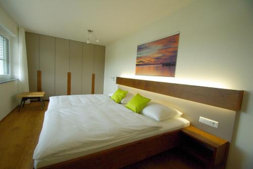 a bedroom with a large white bed with green pillows at Bregenz in Bettnau