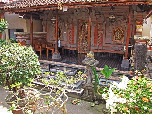 a building with a statue in front of it at Angga Homestay in Ubud
