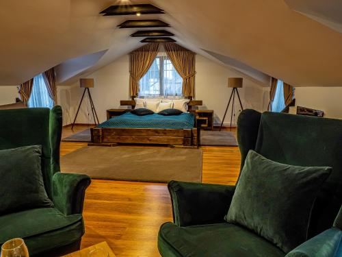 ein Schlafzimmer mit einem Bett und zwei Stühlen in der Unterkunft Casa Delia in Câmpulung Moldovenesc