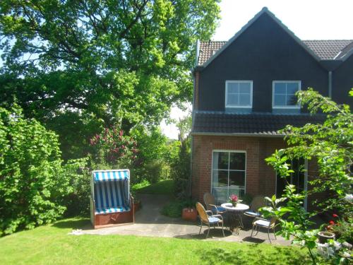 a house with a table and chairs in the yard at Haus Mehler in Heiligenhafen