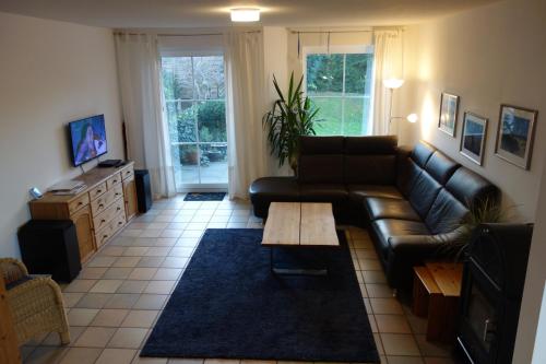 sala de estar con sofá de cuero y mesa de centro en Haus Mehler, en Heiligenhafen